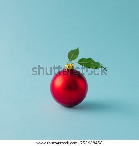 Apple made of red Christmas bauble and leaves on blue background. Christmas food concept.