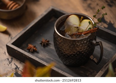 Apple Moscow Mule cocktail in a copper mug on a wooden rustic background. Autumnal Spiced Cider with honey, apple slices, thyme and cinnamon stick as a garnish. Cozy autumn evening. Drink photography - Powered by Shutterstock