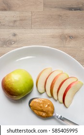 Apple And Peanut Butter In Plant On Top Of Wooden Table