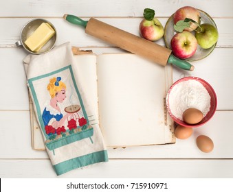 Apple Pie Baking Ingredients With Blank Recipe Book Page, Rolling Pin, Vintage Kitchen Towel, Butter And Eggs On Distressed White Shiplap Table Background.  Horizontal Flat Lay View With Copy Space.