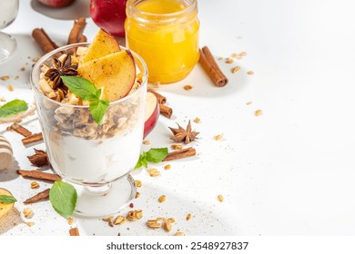 Apple Pie Granola Cheesecake, breakfast snack layered dessert with oat granola, cream cheese yogurt, honey, apple slices and cinnamon spices on white background copy space - Powered by Shutterstock