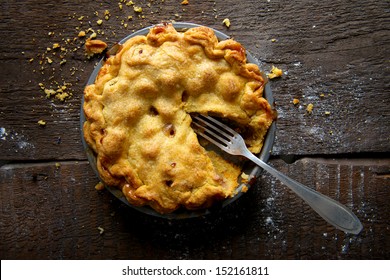 Apple Pie On A Brown Rustic Wooden Background With Fork And Crumbs