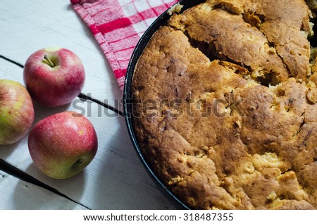 Apple pie on wooden background in a pan