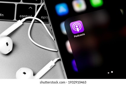 Apple Podcasts Mobile Icon App On Screen IPhone With Headphones Earpods. Apple Podcasts Is The World's Largest Platform For Podcast By Apple Inc. Moscow, Russia - February 20, 2021