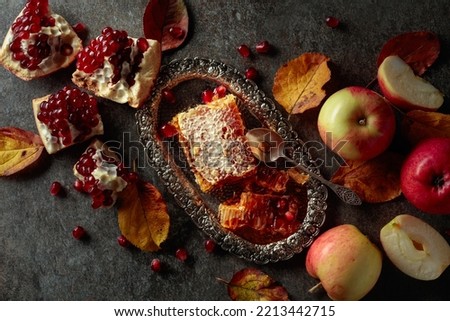 Apple, pomegranate, and honey, are the traditional food for Jewish New Year - Rosh Hashana. Honeycomb and fruits on an old stone table.