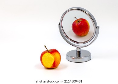 Apple and its reflection in a mirror on white background. Different reflection. White space for text.