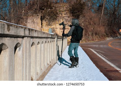 APPLE RIVER CANYON, ILLINOIS - CIRCA JANUARY 2019 - A Teen Takes A Shot Off A Bridge With A Canon Sl2 On A Monopod In The Winter At Apple River Canyon State Park In Illinois