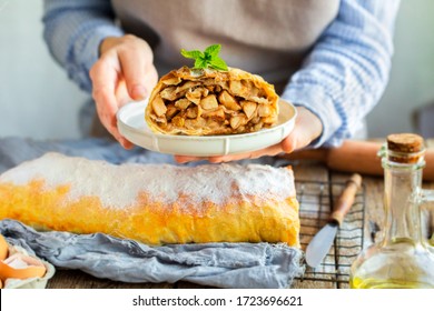 Apple strudel from the oven.Mint on strudel.Housewife is preparing an apple pie.Offer to take a piece of cake.Mom is preparing a dessert.Vienna apple strudel.Sliced ​​piece of cake.cuts home dessert 