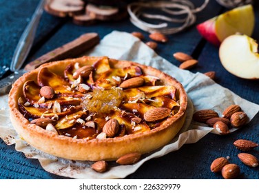 Apple Tart On A Sand Base With Pear Jam And Caramel On Dark Wooden Board