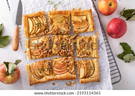 Apple tart with puff pastry topped with sliced apples, walnuts and brown sugar caramel sliced into squares