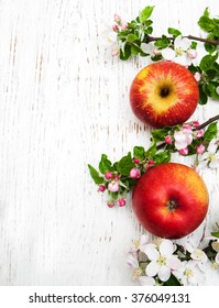 apple and apple tree blossoms on a wooden background