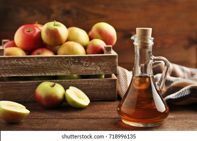 Apple vinegar in glass bottle on brown wooden table