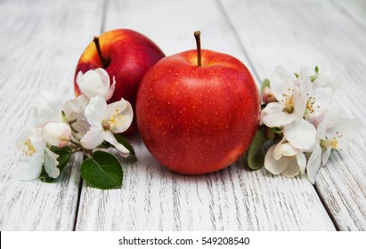 apples and apple tree blossoms on a wooden background