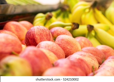 Apples and bananas on sale at grocery market, shallow depth