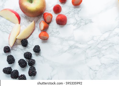 Apples And Berries On Marble Countertop