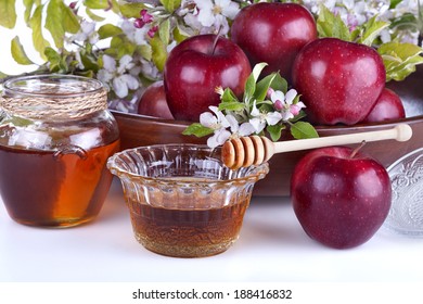 apples in a bowl with honey and apple flower on a white background