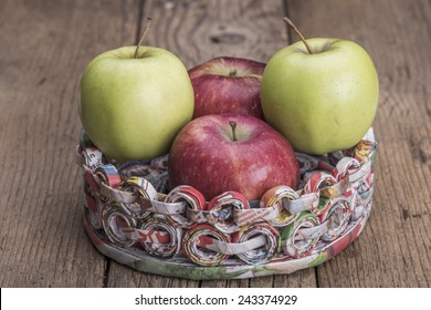 Apples on a support made of recycled paper on wooden surface