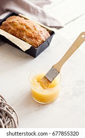 Applesauce And Glazed Oatmeal Loaf Cake In Baking Pan On A White Marble Table. 