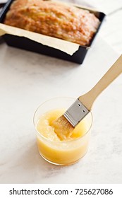 Applesauce And Glazed Oatmeal Loaf Cake In Baking Pan On A White Marble Table. 