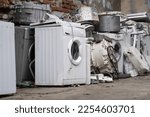 Appliance recycling concept. Old used washing machines on street. E-waste at landfill, local scrap yard