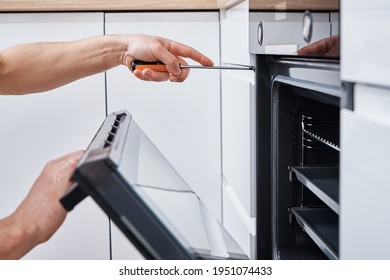 Appliance repair. Man installing electricity oven in the kitchen