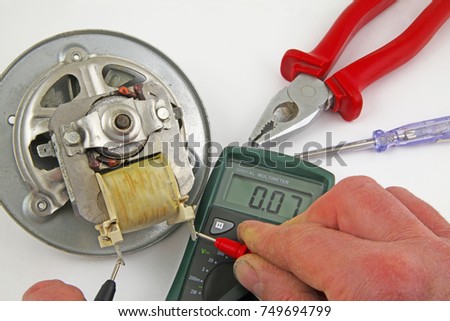  Appliance testing – An engineer fault finding an electric fan motor
