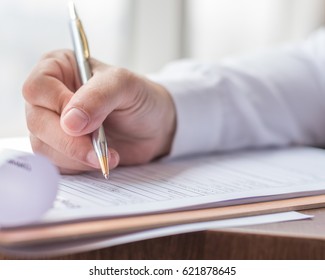 Applicant filling in company application form document applying for job, or registering claim for health insurance - Shutterstock ID 621878645