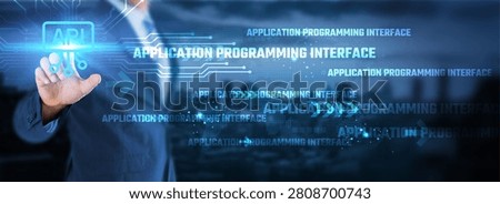 Application Programming Interface (API) concept. Businessman touching a digital API interface button on a futuristic tech background with circuit board lines and network data.