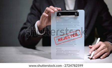 Application rejected and document denied concept. Businessman holding clipboard with red rejected stamp. Business failure, loan disapproval, and negative result.