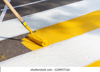 Application Of Road Markings For Pedestrians With Bright Yellow And White Paints. Pedestrian Crossing Over Road. Road Works.