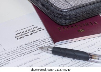 An application sheet for immigrant visa and alien registration to the United States of America. A photo of a foreign passport and a black pen.  - Shutterstock ID 1116776249