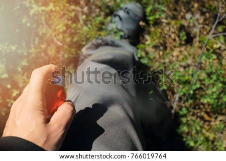application of spray from insects on pants on the nature in the wild forest