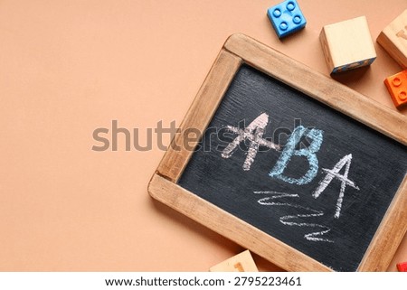 Applied behavior analysis (ABA) therapy concept on chalkboard with building blocks for autism spectrum disorder treatment