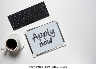 Apply Now . Desk With Apply Now And Computer, Cup Of Coffee On White Backgraund . Work Space