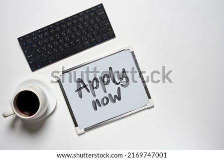 Apply now . Desk with apply now and computer, cup of coffee on white backgraund . Work space