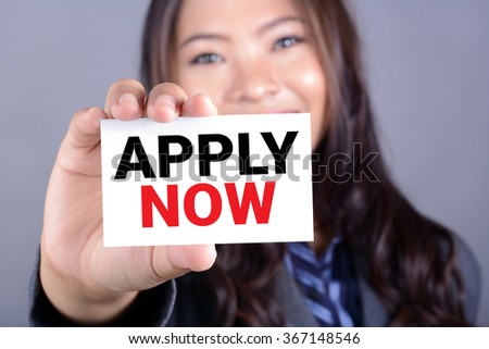 APPLY NOW, message on the card shown by a woman