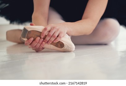 Apply Pressure Then Move On. Shot Of An Unrecognizable Ballet Dancer Putting On Her Pointe Shoes.