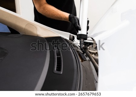 Applying adhesive to a car windshield using a caulking gun. Urethane caulking gun applies flexible adhesive, forming a watertight seal at car windshield replacement