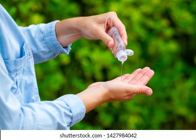 Applying An Antibacterial Antiseptic Hand Gel In Park For Hands Disinfection. Outdoor 