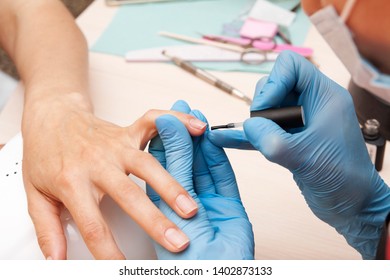 Applying A Base Coat Of Gel Polish In The Manicure Salon 