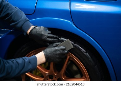 applying black car tire polish on the wheels - Powered by Shutterstock