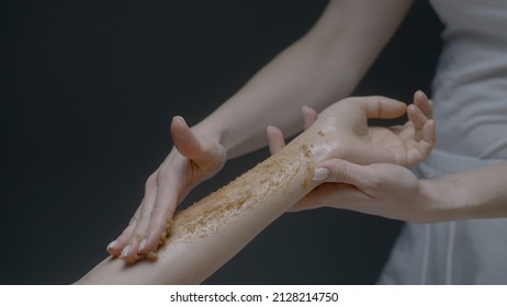 Applying Body Sugar Scrub On Female Client Arm, Concept Of Body Care. Action. Close Up Of Female Cosmetologist Hand During Beauty Procedure At The Salon.