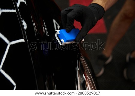 Applying ceramic paint protection to restore vehicle aesthetics is achieved through ceramic coating application applying liquid glass sealant to car hood for scratch resistance.