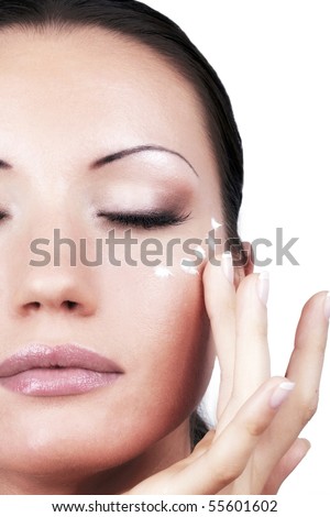Applying cream for eyes area, portrait closeup