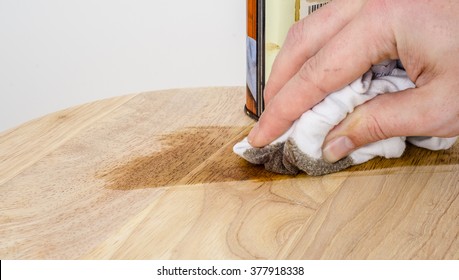 Applying A Dark Oak Stain Onto Wood Using A Cloth.