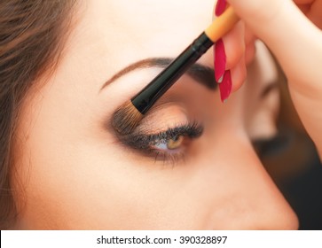 Applying Eye Makeup Products On Woman's Face.