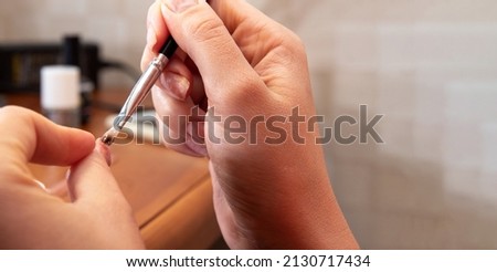Applying gel to the thumbnail. Close-up. The process of self-manicure. Image for beauty websites. Selective focus.