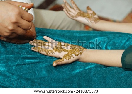 Applying henna mehndi in hands