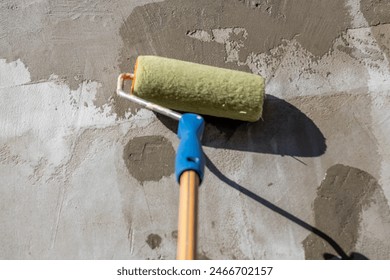 applying primer to the wall with a roller