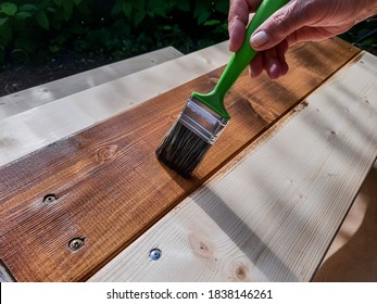 Applying Protective Varnish On A Patio Wooden Floor.Painting Woodwork Outside.hand Use Brush Paint Clear Lacquer On Wood Surface